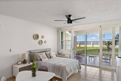 a bedroom with a bed and a balcony with a table at Beacfront Petite Paradise unit at Pelican Reef 103 in Rincon