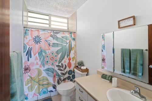 y baño con aseo y cortina de ducha. en Beacfront Petite Paradise unit at Pelican Reef 103 en Rincón