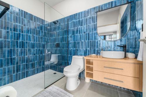 Baño de azulejos azules con aseo y lavamanos en Casa Loba Luxe Unit 3 with private pool en Rincon