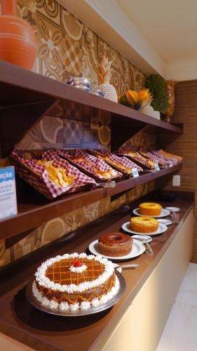 a buffet line with cakes and other desserts on plates at Atlântico Praia Hotel in João Pessoa