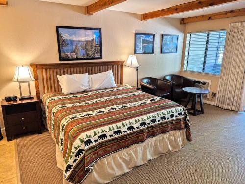 a bedroom with a bed and a chair and a table at Lakeland Village #105 in South Lake Tahoe
