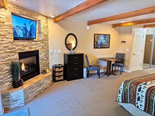 a bedroom with a fireplace and a bed and a table at Lakeland Village #105 in South Lake Tahoe