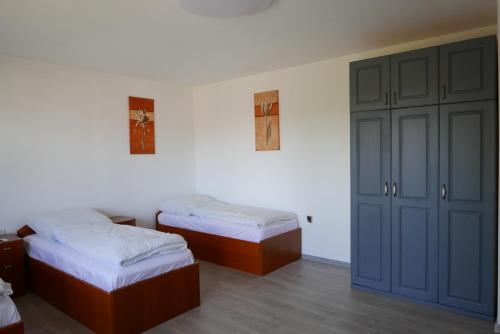 a room with two beds and a closet at Szabó Porta Vendégház in Zalaháshágy