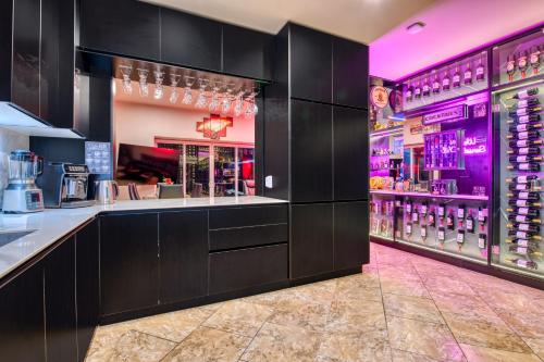 a bar in a restaurant with purple lighting at SecretJaco - Luxury Beach Front Penthouse with Pool & Jacuzzi in Jacó