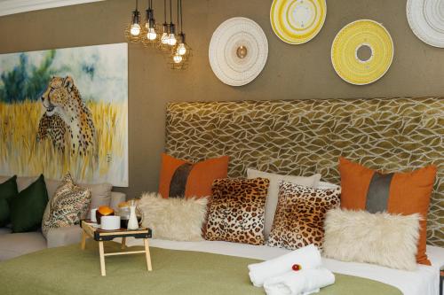 a living room with a bed with leopard pillows at Pumbaa Wildlife Park & Accommodation in Nelspruit
