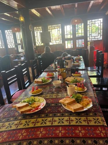 a long table with plates of food on it at Sapa Garden Bungalow in Sa Pa