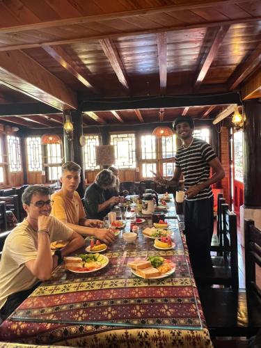 a group of people sitting around a table with food at Sapa Garden Bungalow in Sa Pa