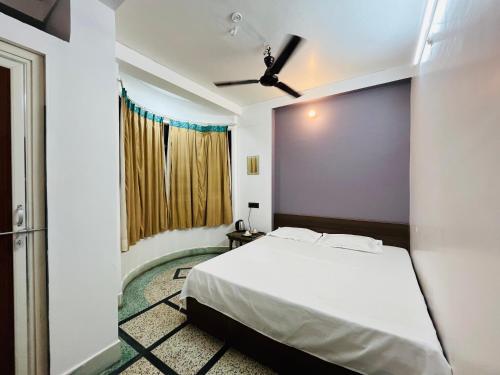 1 dormitorio con 1 cama y ventilador de techo en Ganga Guest House, en Varanasi