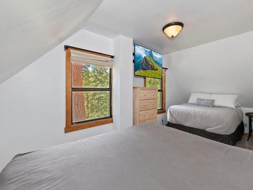 1 dormitorio blanco con 2 camas y ventana en 136 - Historic Rustic Cabin en Big Bear Lake