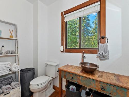 baño con aseo y lavabo y ventana en 136 - Historic Rustic Cabin, en Big Bear Lake