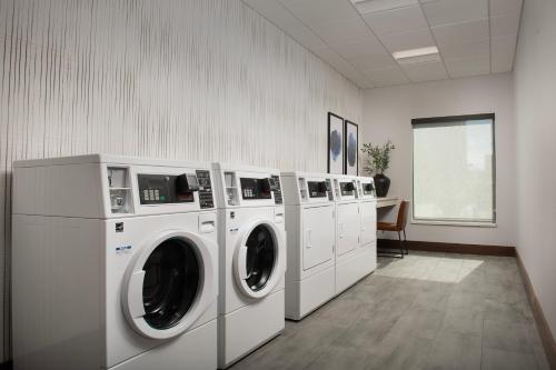 a laundry room with four washing machines and a table at Courtyard by Marriott Bozeman in Bozeman