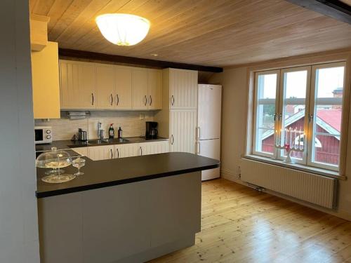 eine Küche mit einer Theke, einem Kühlschrank und einem Fenster in der Unterkunft Penthouse close to Vasaloppet finish line portal in Mora