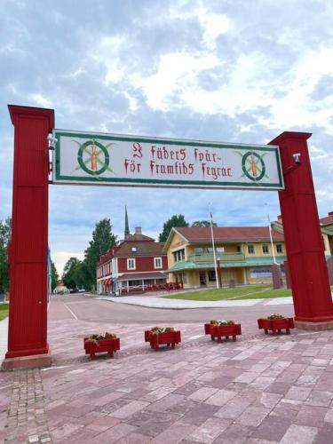 a large red arch with red benches in a parking lot at Penthouse close to Vasaloppet finish line portal in Mora
