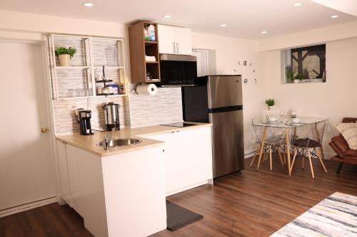 a kitchen with a stainless steel refrigerator and a table at bedford - Urban escape in Montréal