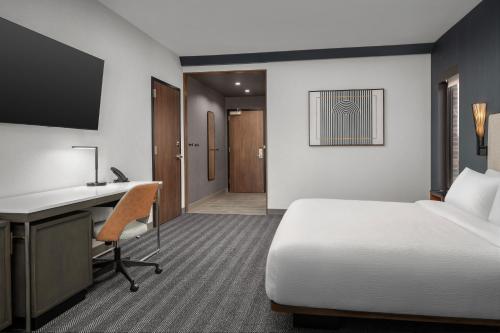 a hotel room with a bed and a desk with a computer at Courtyard by Marriott Bozeman in Bozeman