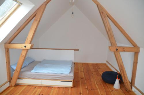 Bett in einem Zimmer mit Holzböden in der Unterkunft Ferienwohnung Uckermarkblick in Ziehten