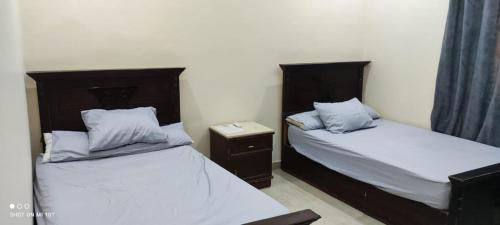 1 dormitorio con 2 camas y mesita de noche en Banna House, en Abu Simbel