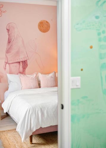 a bedroom with a bed with pink walls at The Acoma House in Denver