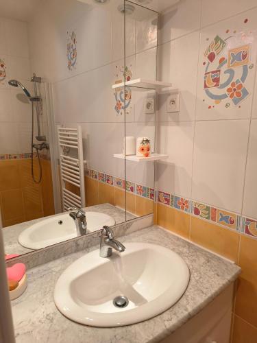 uma casa de banho com um lavatório, um chuveiro e um espelho. em L'Orée em Verneuil-en-Halatte