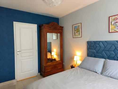 um quarto com uma cama, um armário e um espelho em L'Orée em Verneuil-en-Halatte