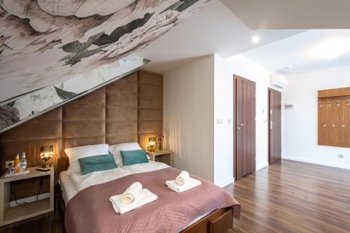a bedroom with a large bed with towels on it at Hotel i Restauracja Stara Kuźnia in Dobczyce