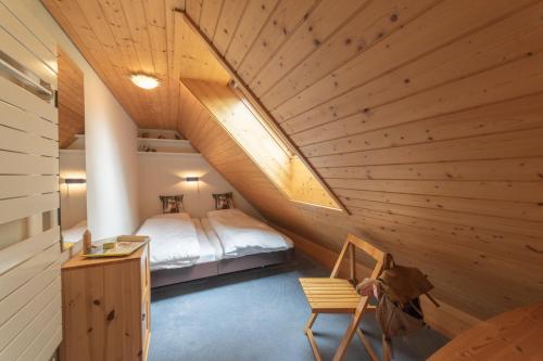 Schlafzimmer im Dachgeschoss mit einem Bett und einer Holzdecke in der Unterkunft Vista Montagna in Unterwasser