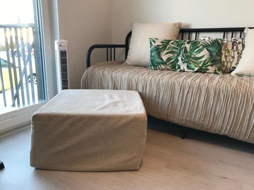 a couch with a ottoman in a living room at Modern Studio, free parking & wifi in Järvenpää