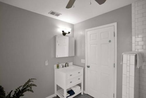 baño blanco con lavabo y puerta blanca en 1940 cottage seen on FYI, 2bd 2ba, en Gainesville