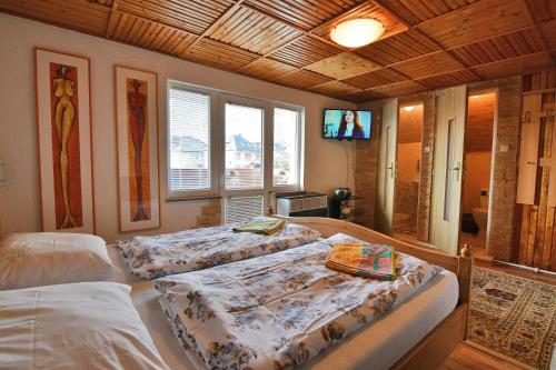 een slaapkamer met drie bedden en een televisie. bij Ubytovanie u Jozefa / Strba in Štrba