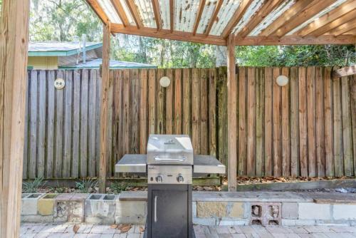 a barbecue grill in front of a wooden fence at 1940 cottage seen on FYI, 2bd 2ba in Gainesville