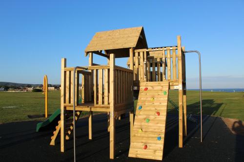 a playground with two wooden play equipment at Driftwood Heart in Freshwater