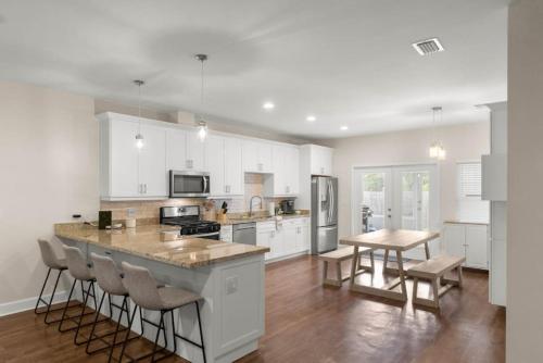 a kitchen with white cabinets and a table and chairs at The Gator Grove Retreat in Gainesville