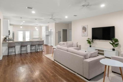 a living room with a couch and a kitchen at The Gator Grove Retreat in Gainesville