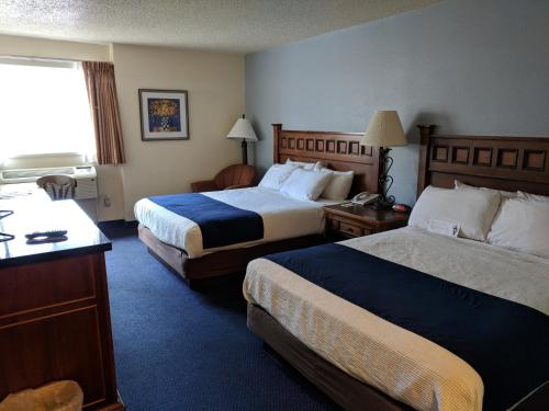 a hotel room with two beds and a window at Broadway Inn Conference Center in Missoula