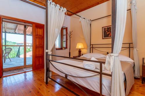 a bedroom with a bed and a balcony at VILLA - APA in Gythio
