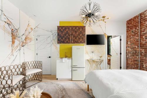 a bedroom with a white bed and a brick wall at The Acoma House in Denver