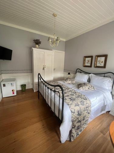 a bedroom with a large bed with white sheets at La Belle Provence in Itaipava