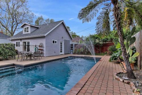 a swimming pool in front of a house at Oasis East Sac Charming Home with Saltwater Pool and Casita in Sacramento