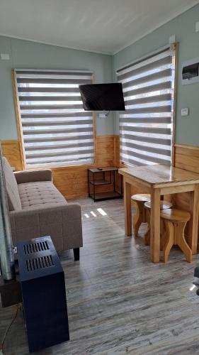 sala de estar con mesa y sofá en Balmaceda Loft, en Puerto Natales