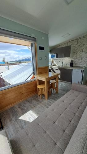 uma cozinha com uma mesa e uma grande janela em Balmaceda Loft em Puerto Natales