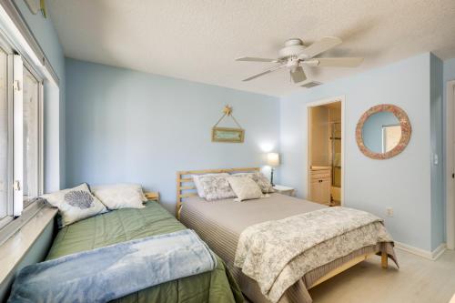 a bedroom with two beds and a ceiling fan at Beachfront St Augustine Condo with Pool Access in Saint Augustine