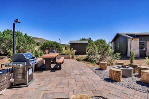 a patio with a grill and a table and some logs at Inn History Grand Canyon Cabin in Williams