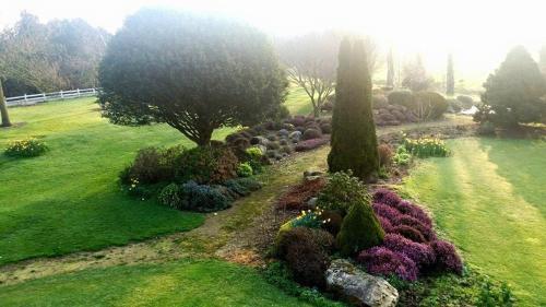a garden with flowers and trees in a field at Chambres d'Hotes Belard in Plonévez-Porzay