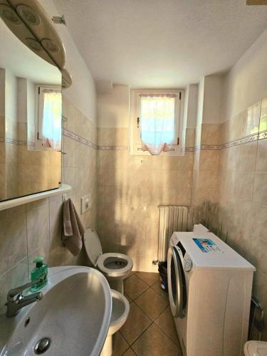 a bathroom with a sink and a washing machine at Stephanie Residence - in the heart of Alps above Varenna, Lake Como in Esino Lario
