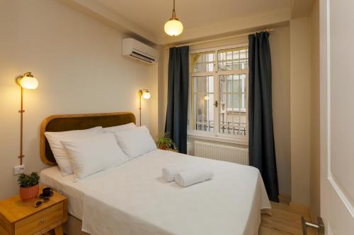 um quarto com uma cama branca e uma janela em Lemon Apartments em Istambul