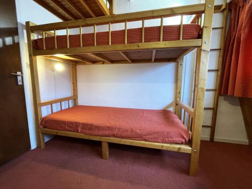 - un lit superposé en bois avec un matelas rouge dans l'établissement Studio Économique pour 2 pers, Pied des Pistes - Les Menuires (Animaux Acceptés) - FR-1-452-288, aux Menuires