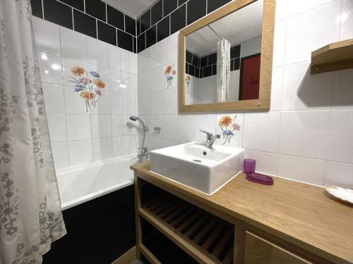 une salle de bain avec un lavabo, un miroir et une baignoire dans l'établissement Studio duplex 4 personnes avec balcon, Brelin, Les Menuires - FR-1-452-151, aux Menuires