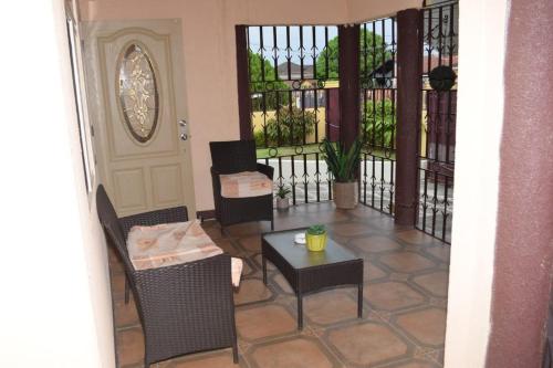 sala de estar con mesa, sillas y puerta en Rhyne Park Inn, en Montego Bay