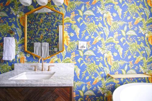 a bathroom with a sink and a blue and gold wallpaper at Carriage House on Chatham Sq in Savannah