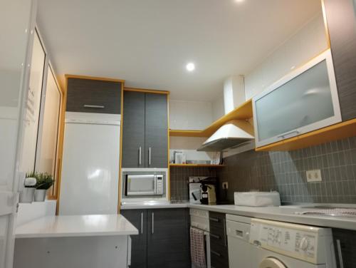 a kitchen with a white refrigerator and a microwave at La Alameda Jardines del Prado -Amplio y con ascensor- in Talavera de la Reina